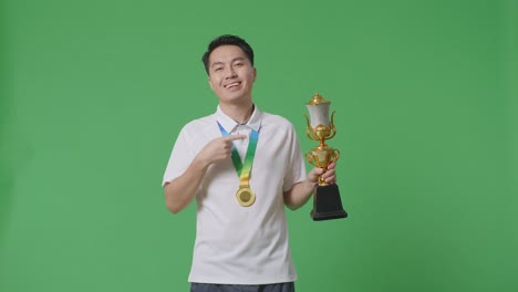 man holding a trophy and medal