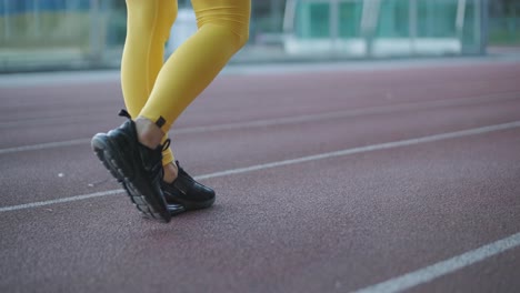 woman jogging on outdoor track in sportswear at athletic field