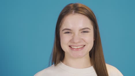 una mujer joven sonriente mirando a la cámara divertida y feliz.