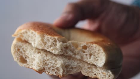 Holding-half-eaten-fresh-bagel-bread