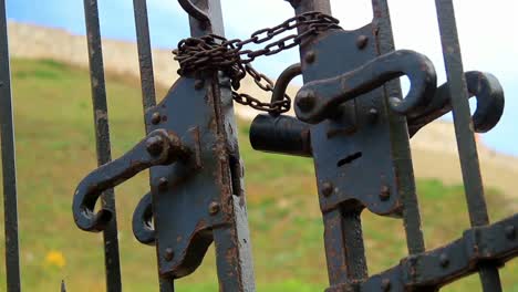 an old chain and a large lock on a metal black gates