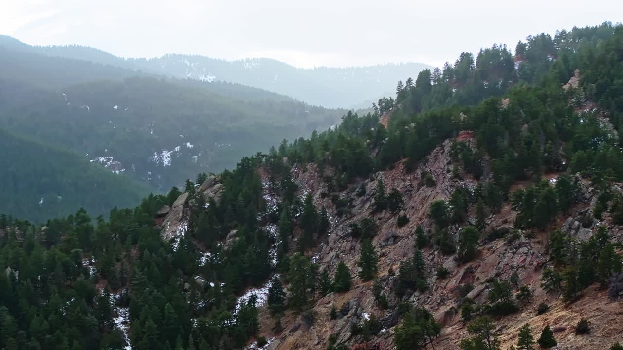 Tracking drone shot across Boulder Flatirons cliffs, highlighting rugged details and vegetation