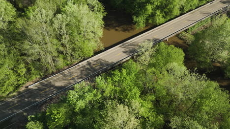 wolf river winding through lush greenery with a bridge in collierville, tn, aerial view