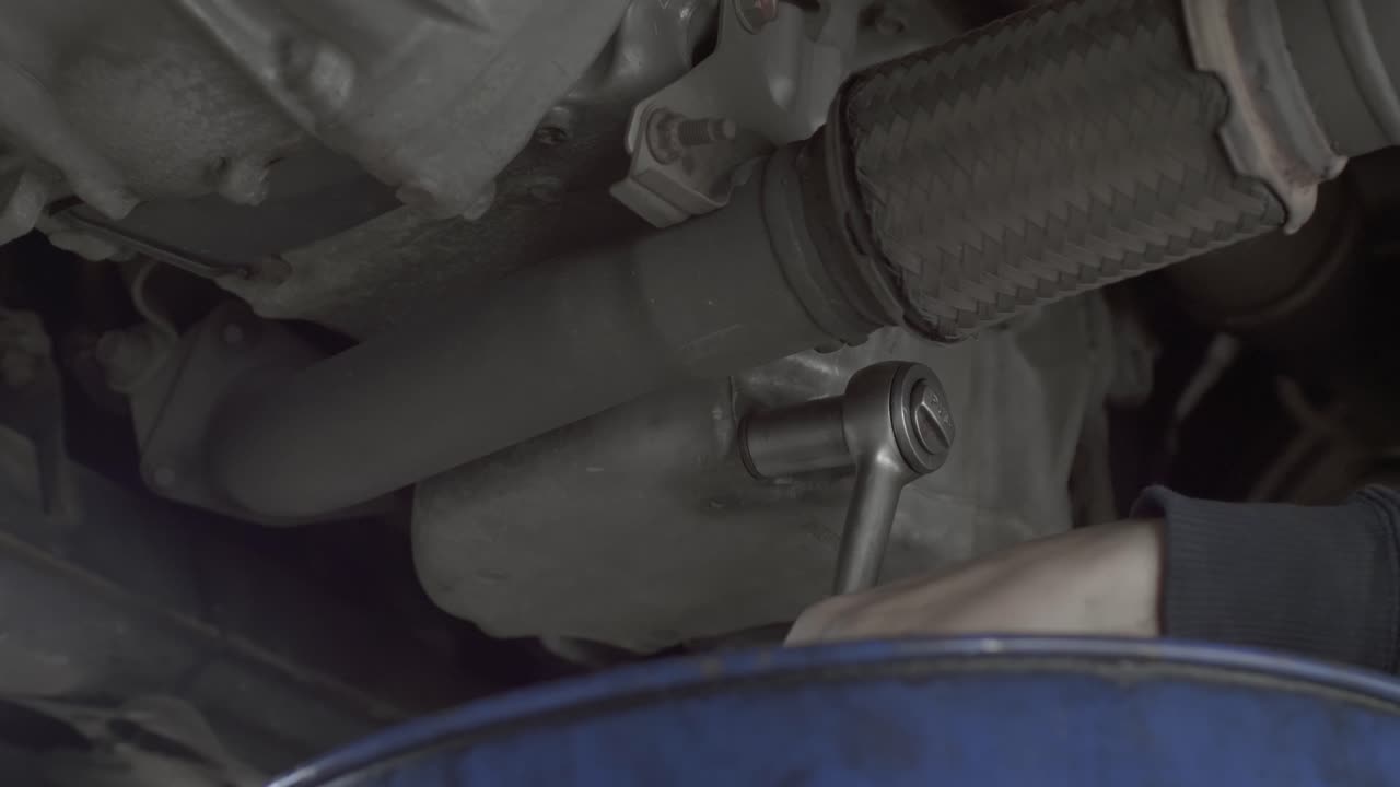 그는 너트를 풀기 위해 래칫 스패너와 고군분투하면서 기계공의 손을 닫습니다