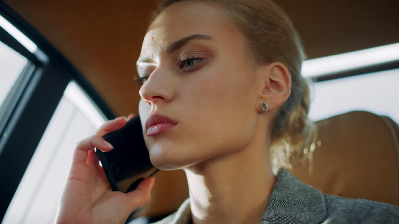 грустная деловая женщина разговаривает по мобильному телефону. расстроенная девушка сидит с телефоном в машине