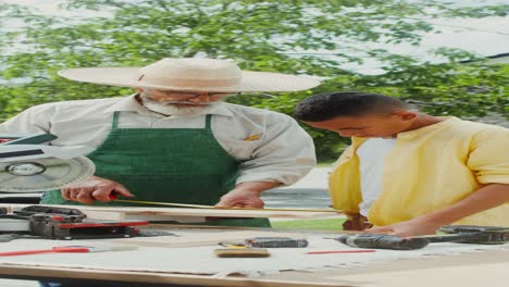 grandfather teaching grandson woodworking