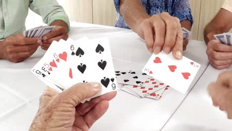 un anciano y una anciana jugando a las cartas en un hogar de ancianos