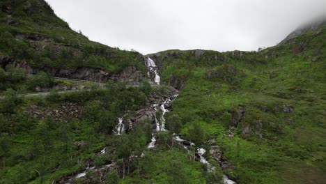 flying away from waterfall in narrow valley on senja in norway