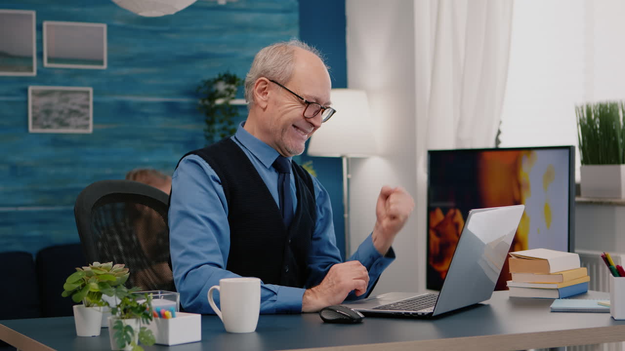 el anciano se siente emocionado, extasiado leyendo grandes noticias en línea.