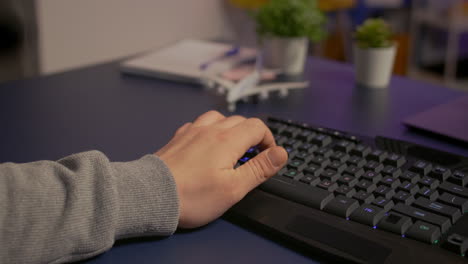 Closeup of gamer typing on professional RGB keyboard