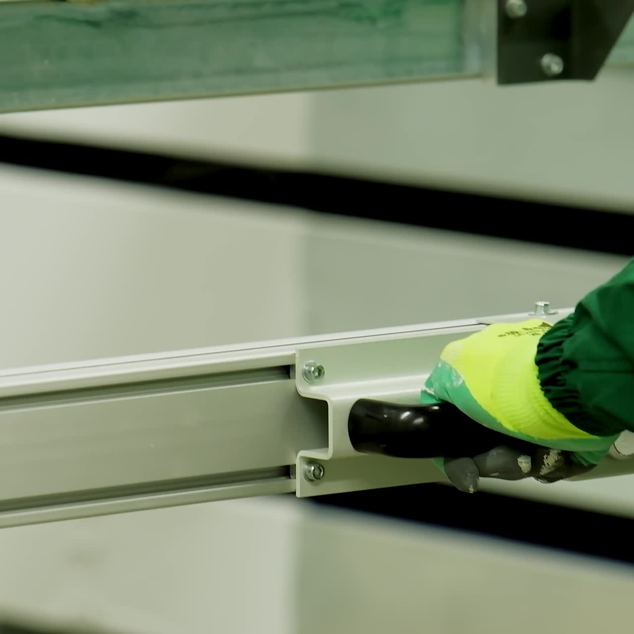 Manufacture of doors. Hands of industrial worker inside factory. Metal frame for door production. Close-up.