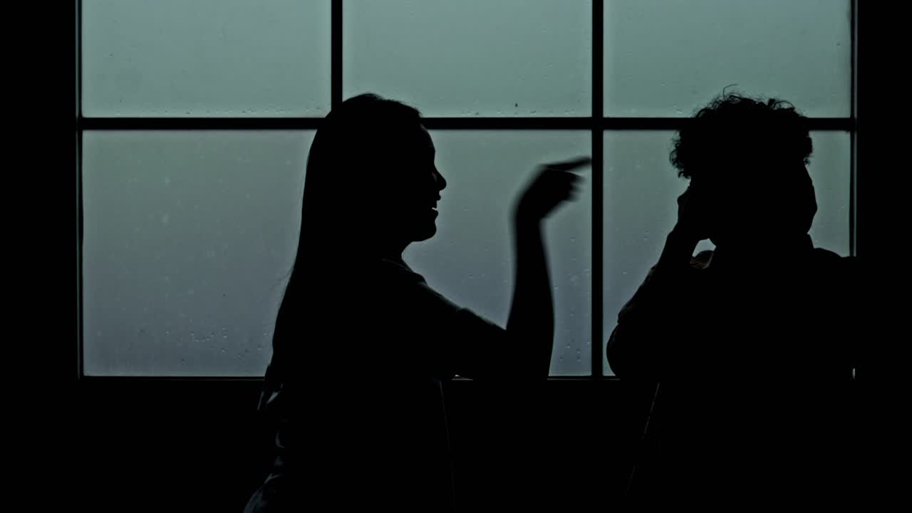 Moody silhouette of couple in heated domestic argument