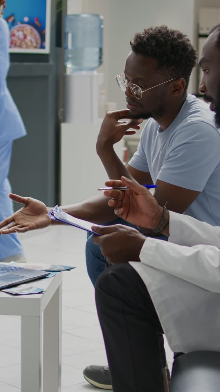 Vertical video: Specialist talking on videocall conference with physician