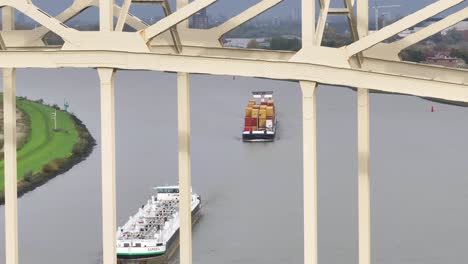 under large steel bridge vessels carrying goods onwards to next destination