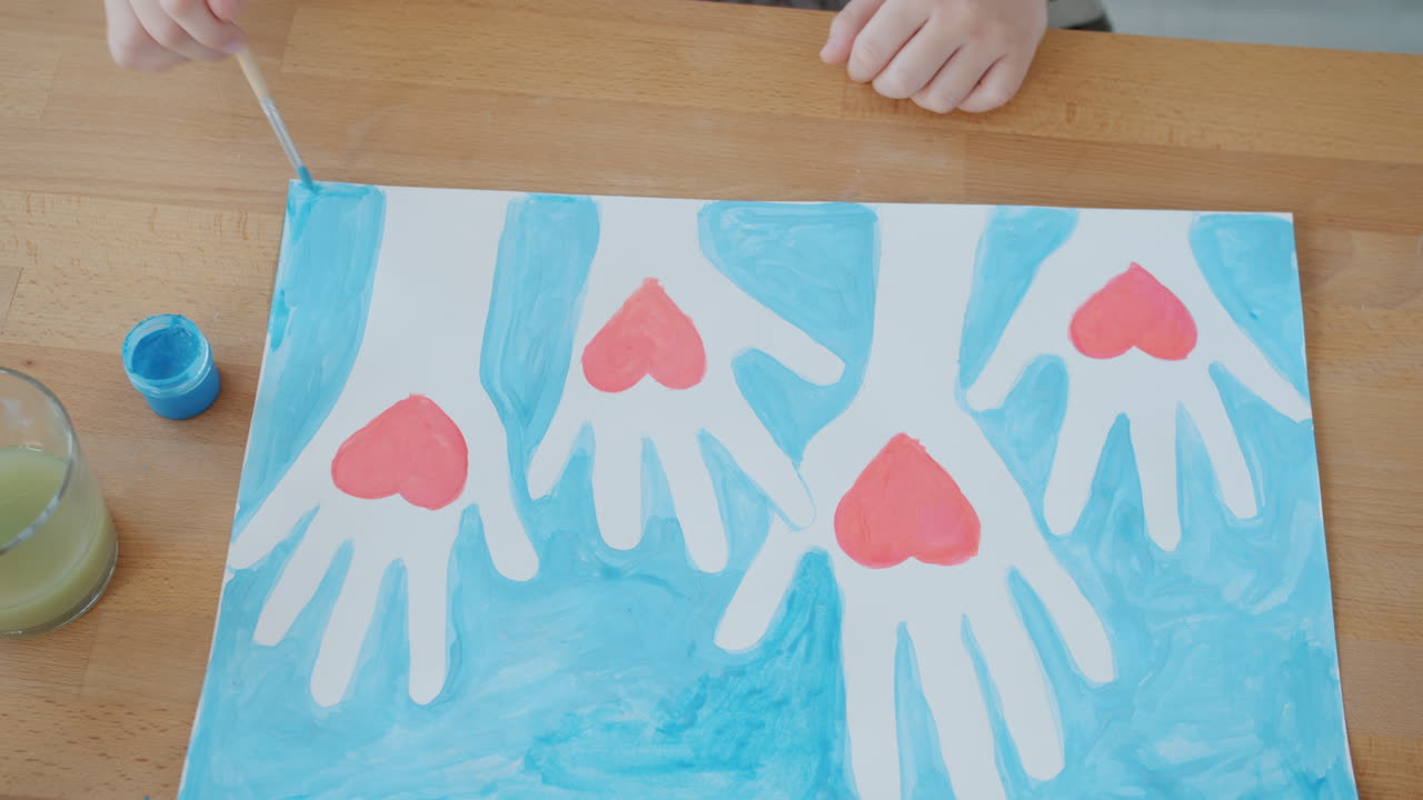 Child Painting Hands with Hearts