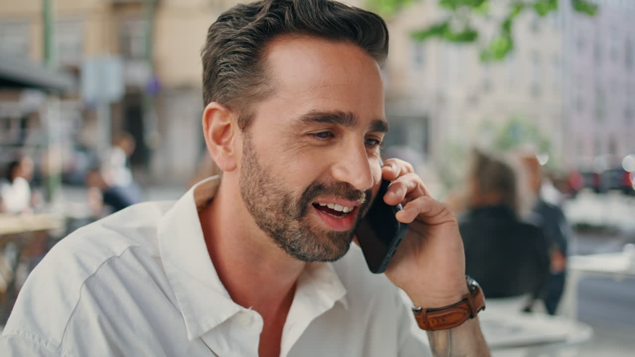 Cheerful man talking cell sharing good news at city closeup. Freelancer laughing