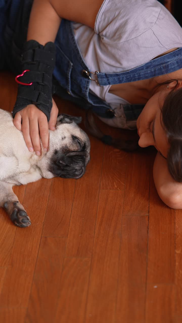 chica con perro pug en el suelo