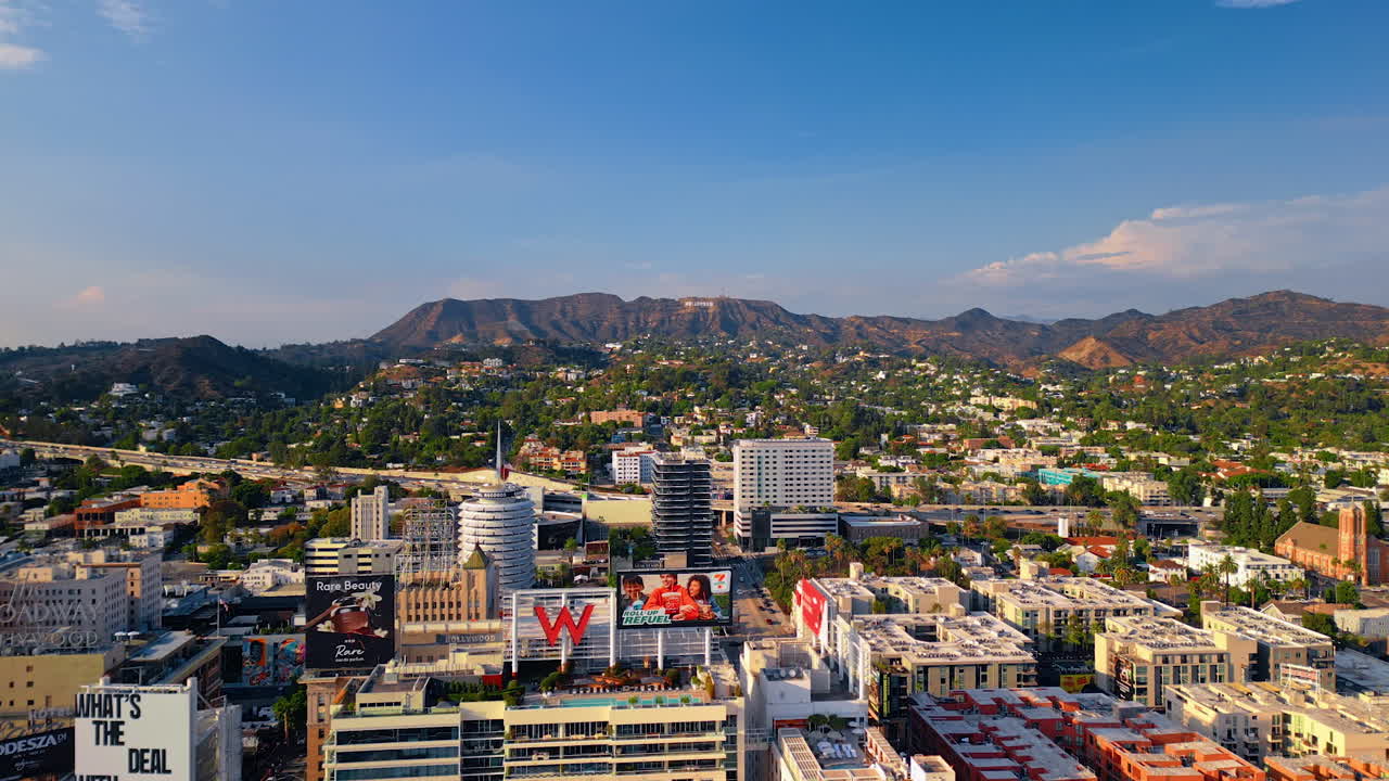 Los Angeles, USA, 29 August 2025: Beautiful scenery of sunny urban landscape of Los Angeles, California, USA at sunset. Approaching the mountain range with Mount Lee and Hollywood sign on