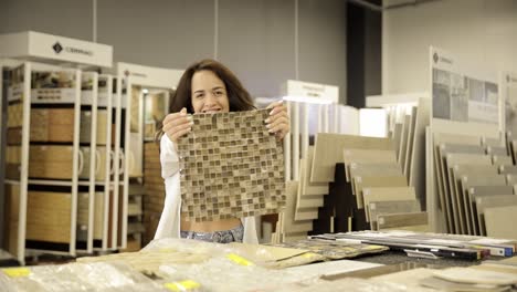young woman choosing ceramic tiles.