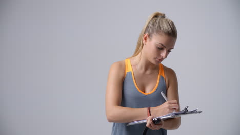 Slow-Motion-Sequence-Of-Female-Sports-Coach-With-Clipboard