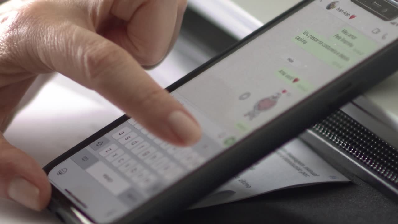Closeup, white female hand wearing ring texting message on cell phone