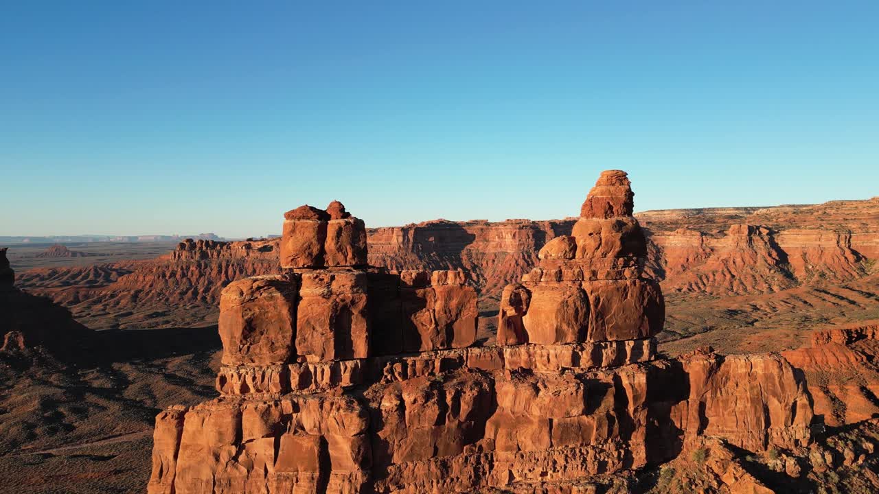 Ripresa aerea con drone di una formazione di arenaria, Rudolph e Babbo Natale vengono rivelati allontanandosi, enfatizzando la loro imponente dimensione nel paesaggio desertico nella Valley of the Gods, Utah, USA