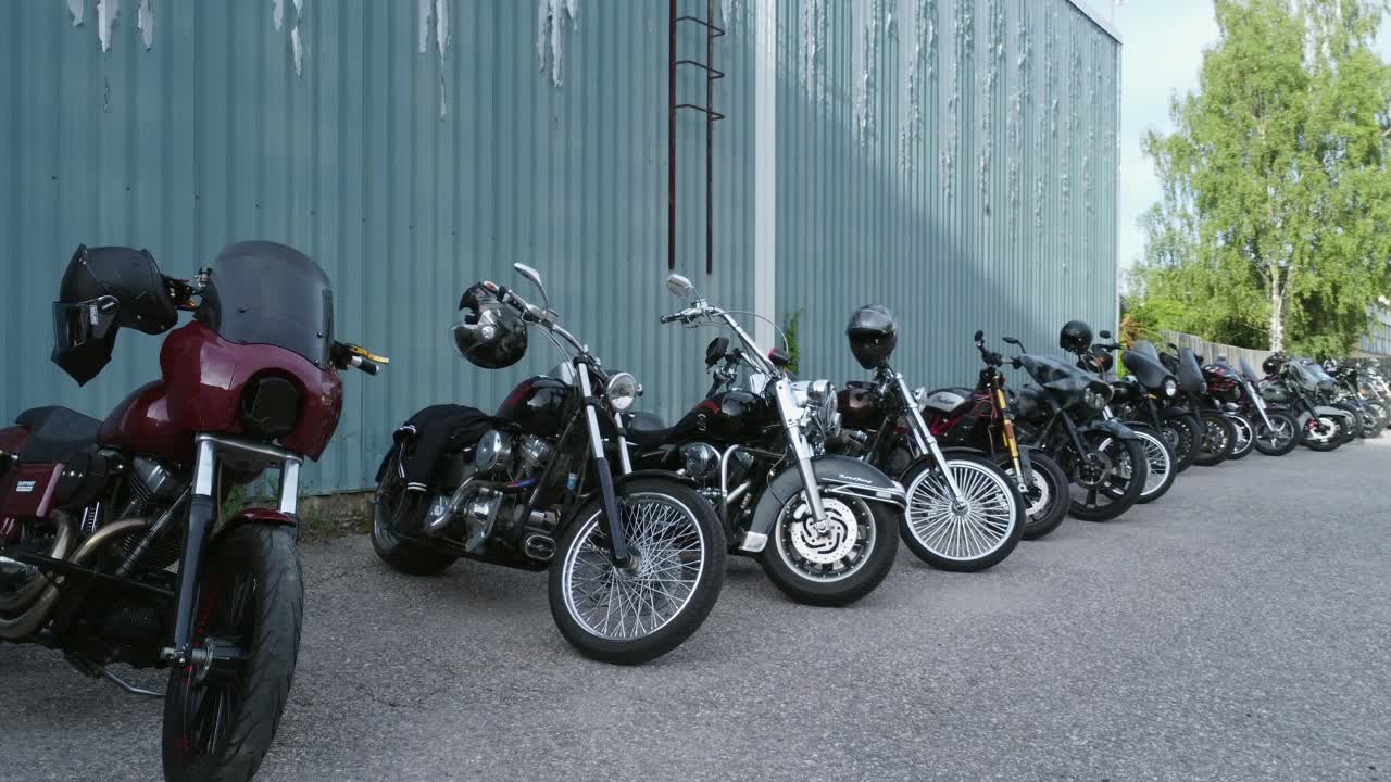 Shiny custom motorcycles line up by building for bike rally in Finland