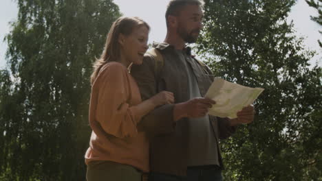 family hiking and reading a map in the forest