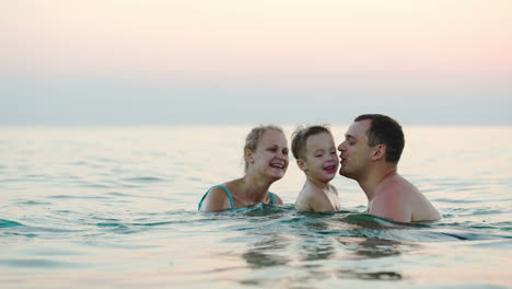 Glückliche-Dreiköpfige-Familie,-Die-Im-Meer-Badet