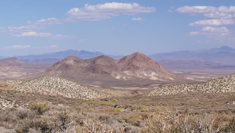 timelapse of amargosa desert with clouds over red mountain peak and valley, nevada