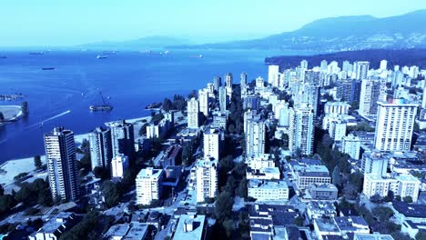 barge-beached-in-Vancouvers-sunset-beach-business-as-usual-as-speed-boats-pass-by-and-tourists-enjoy-the-view-aerial-panoramic-flyover-westside-of-downtown-BC-mountain-overview-reveal-4k-beauty