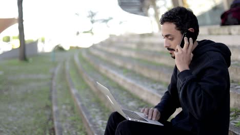 man using laptop and talking by cell phone