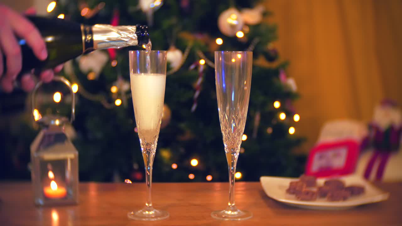un hombre vierte una copa de champán en navidad