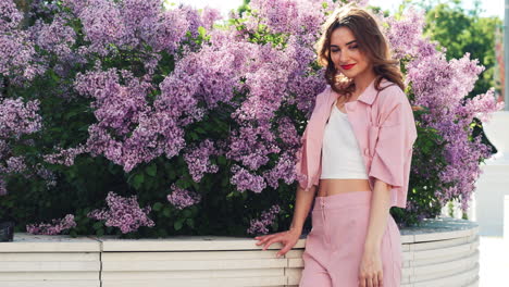 woman in pink suit among lilacs