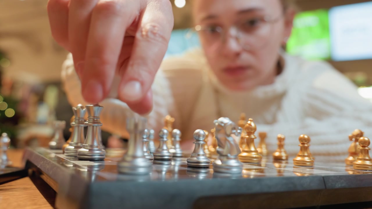Fokussierte Frau plant ihren nächsten Zug im Schachspiel