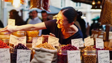 woman at a market selecting dried food products