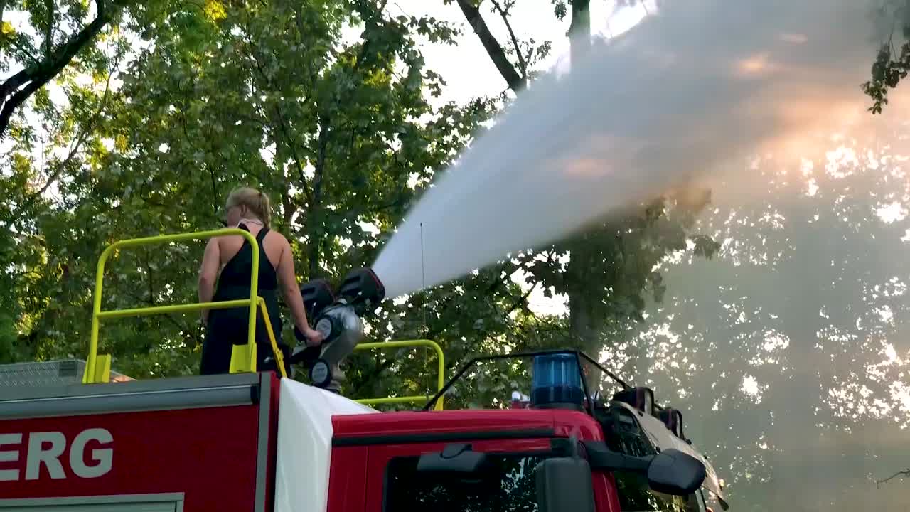 camión de bomberos alemán rociando agua para niños y árboles en un caluroso día de verano-14