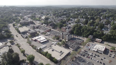 Flying-slowly-up-high-wide-panorama-of-Marlborough,-Massachusetts-down-town-and-surrounding-neighborhoods-and-streets