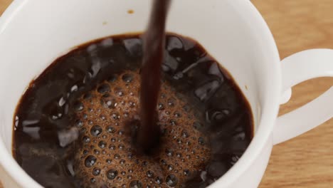 vierte café caliente en una taza blanca.