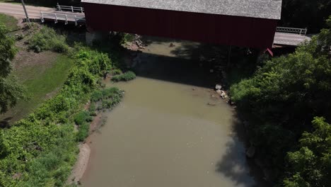 Historic-Red-Covered-Bridge-in-Princeton,-Illinois-along-the-Big-Bureau-Creek-with-drone-hyperlapse-video