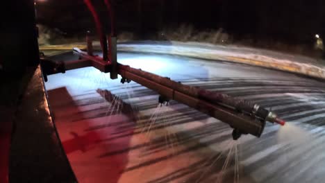 camión de deshielo rociando líquido de deshielo en un estacionamiento público durante el invierno