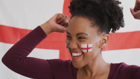 video of excited afrcian american woman with flag of england watching match in tv