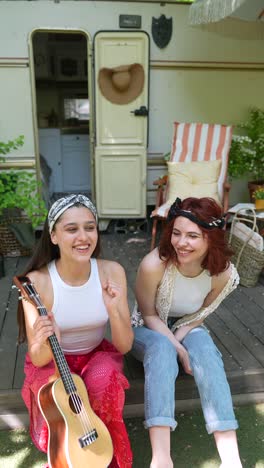 two friends enjoying music outdoors by a campervan