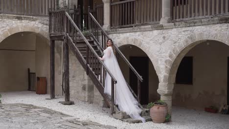 Una-Novia-Posa-Para-Fotografías-En-Las-Escaleras-De-Una-Villa-De-Adoquines-Griega.