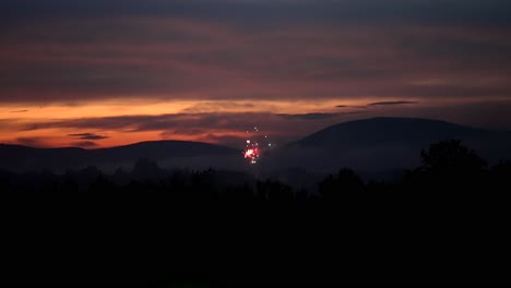 Los-Fuegos-Artificiales-Rojos-Brillan-Y-Se-Lanzan-Al-Aire-En-Cámara-Lenta-Al-Atardecer,-Vista-De-Gran-Angular