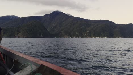 crossing the reloncavi inlet by ferry to la arena cove. view of mountains covered with native forest.