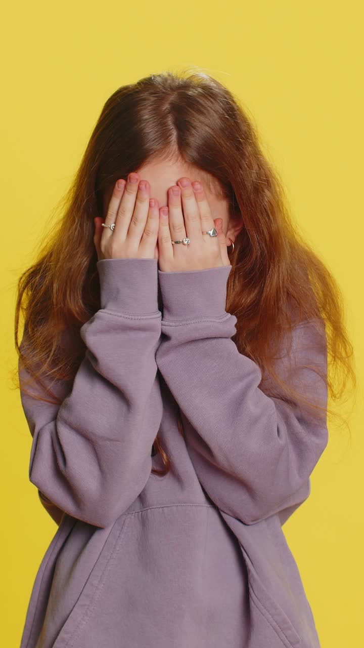 Curious preteen child girl kid closing eyes with hand and spying through fingers hiding and peeping