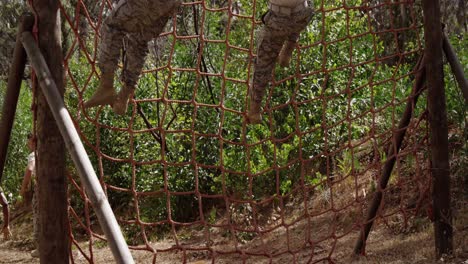 military troops climbing a net during obstacle course 4k