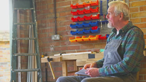 Granddaughter-With-Grandmother-Bringing-Grandfather-Cake-And-Hot-Drink-In-His-Home-Workshop