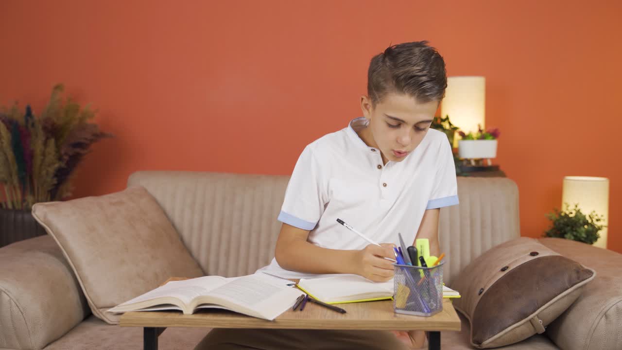 소년은 집에서 공부하고, 문제를 해결하고 있습니다.